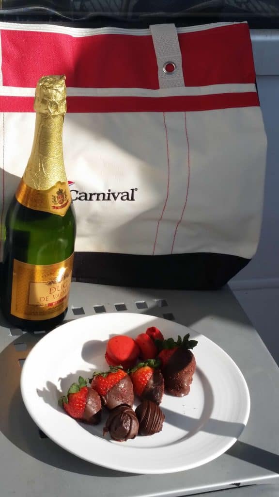 chocolate covered strawberries and champagne with a carnival bag