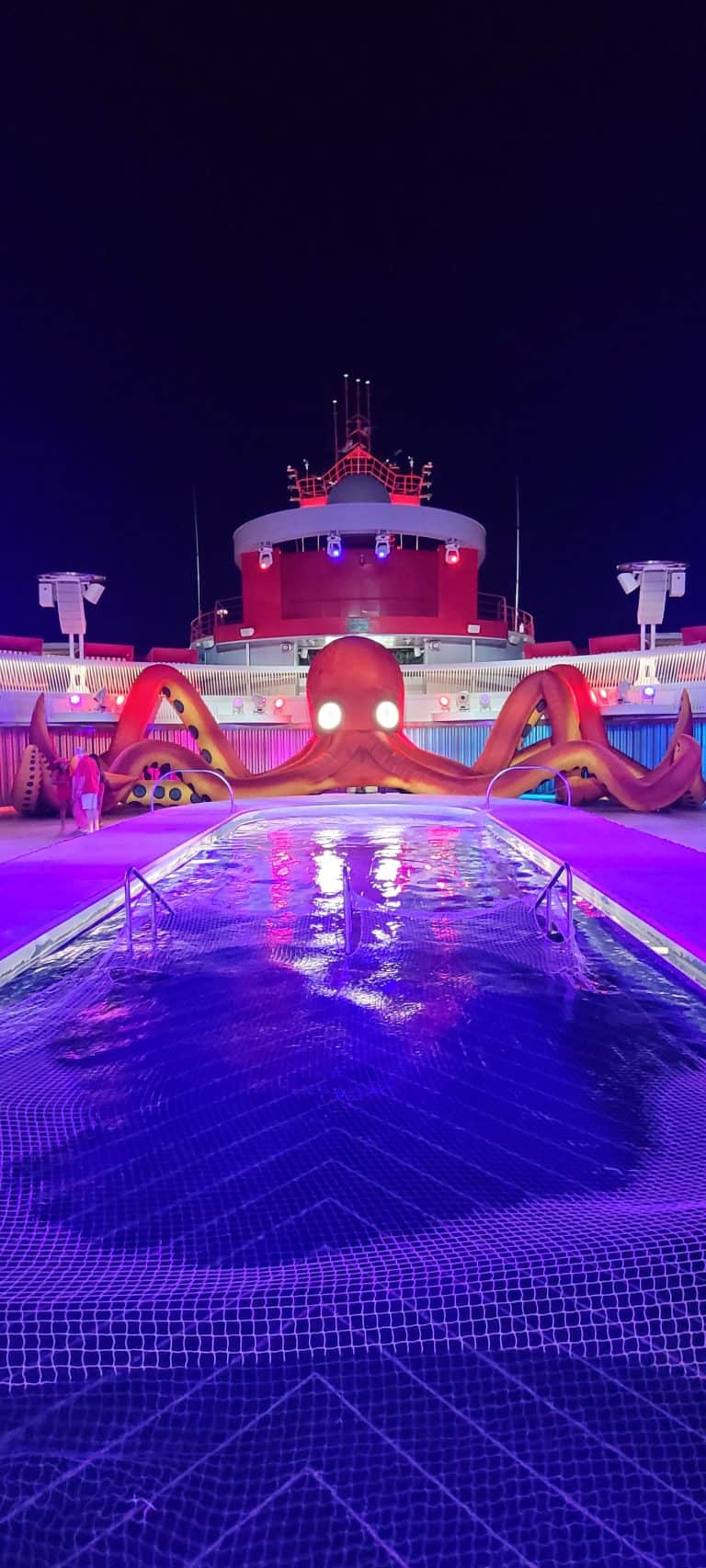 Virgin Voyages Pool deck on Scarlet Night with a large blow up octopus