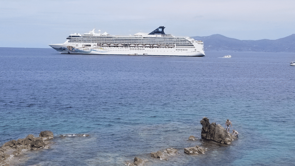 NCL cruise ship sailing the Mediterranean Sea with a tender boat nearby, perfect for exploring Europe by cruise.