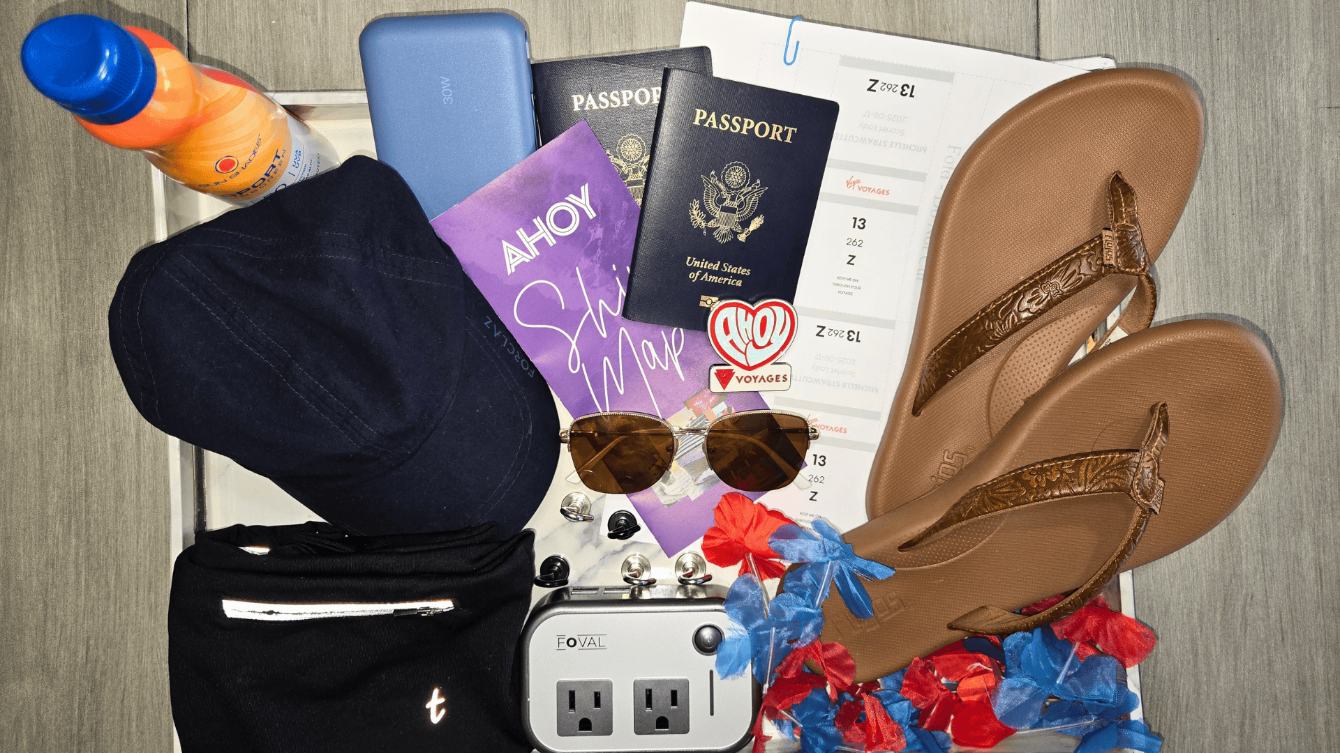 Cruise prep pre-pack pile flat lay with passport, flip-flops, sunscreen, power adapter, boarding pass, and travel essentials staged for a cruise.