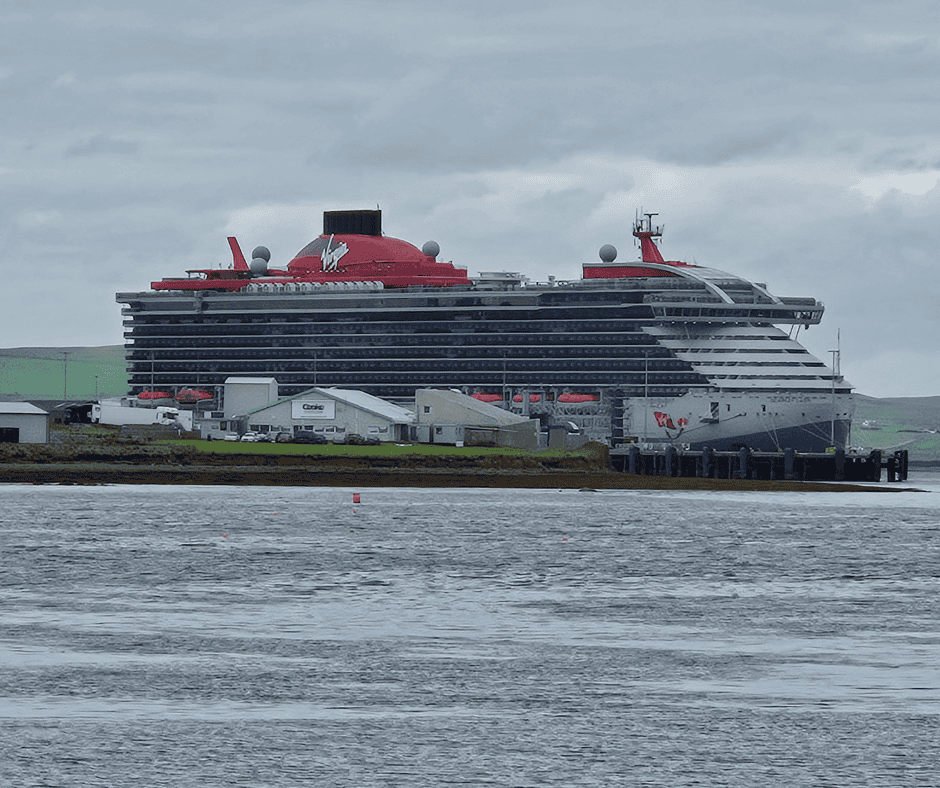 Virgin Voyages Scarlet Lady docked in Kirkwall, Scotland, a popular adults-only cruise line for European itineraries.