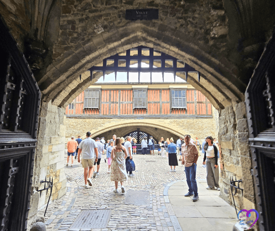 Visitors walking through stone archway, symbolizing awareness and safety during European travels.