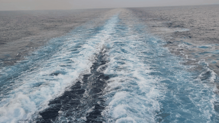Ocean wake from a cruise ship at sunrise, symbolizing relaxation, fresh air, and healthy cruising at sea.