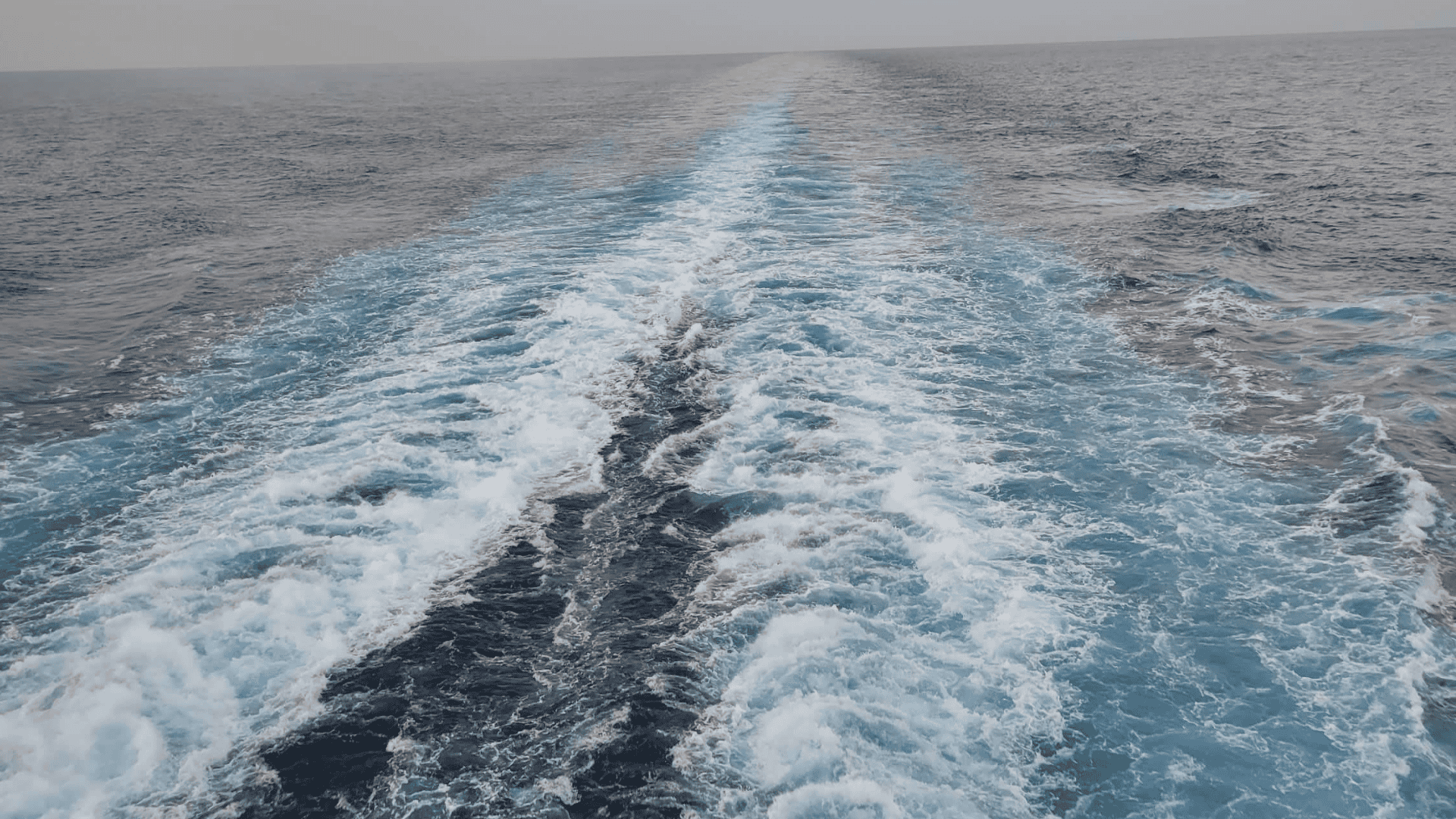 Ocean wake from a cruise ship at sunrise, symbolizing relaxation, fresh air, and healthy cruising at sea.